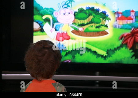 A young child watching cartoons on tv Stock Photo