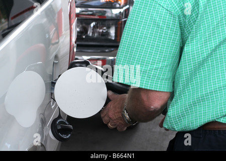 A man filling up gas tank at a service station Stock Photo