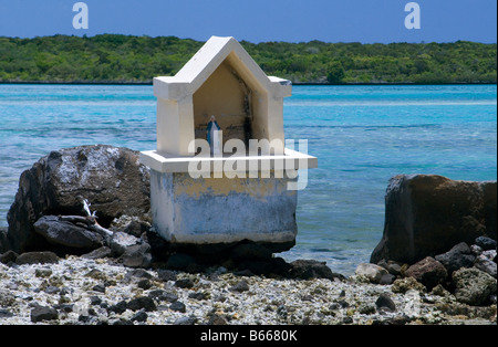 Shrine to the Blessed Virgin Mary on a small island with turquoise coral filled sea and Ile aux Aigrettes, Mauritius.