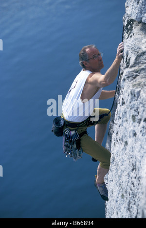Male rock climber reaching for a grip Stock Photo