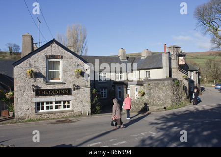 Winter Visitors outside The Old Inn in the Centre of Widecombe in the Moor Dartmoor Devon Stock Photo