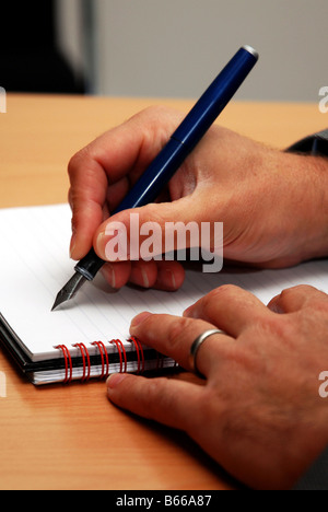 Mans hand writing in a notebook Stock Photo