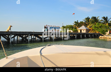 The full staff of the luxurious Cayo Espanto in Belize welcomes all arriving guests to their private island resort villas. Stock Photo