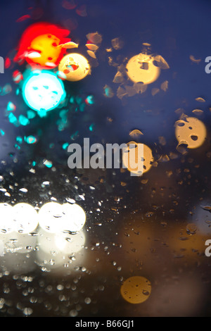 city car drive with lights and rain on windshield Stock Photo