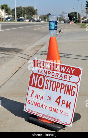 Orange traffic cone with sign informing about temporary parking restrictions Stock Photo