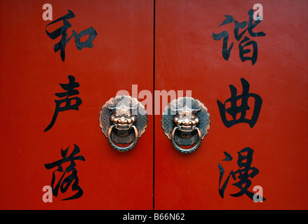 Lion knocker on red door in Beijing, China Stock Photo