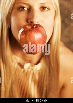Mid-Adult Woman with Apple in Her Mouth Stock Photo
