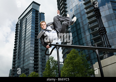 Businessman swinging on railing Stock Photo