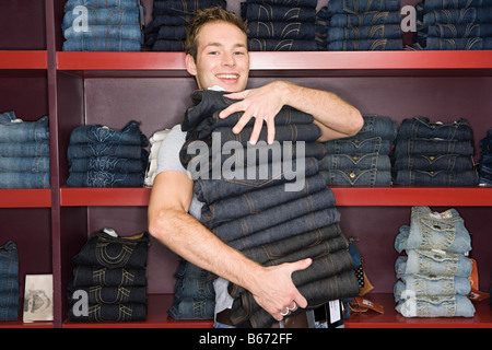 Man holding a stack of jeans Stock Photo