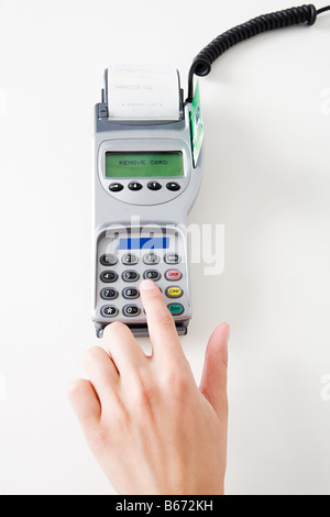 Woman using a chip and pin machine Stock Photo