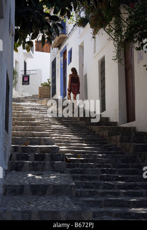 Young woman climbing the stairs in a narrow cobbled street in Altea, Spain Stock Photo