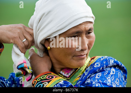 Traditionally dressed ethnic Mongolian attends summertime Naadam Festival Xiwuzhumuqinqi Inner Mongolia China Stock Photo