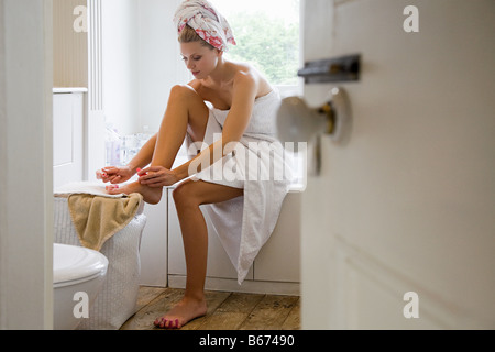 Young woman painting toenails Stock Photo