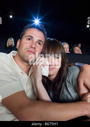 A man comforting a woman watching a sad movie Stock Photo