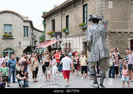 a mime artist in carcassone la cite France painted in pure Gray stopping and making actions like a moving statue Stock Photo