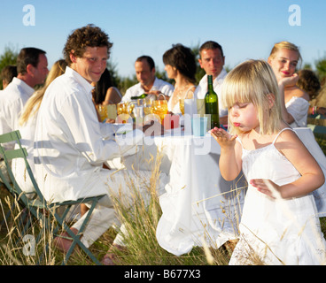 People having dinner in a field Stock Photo