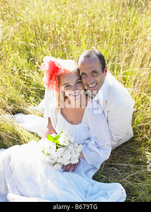 Married couple sitting in a field Stock Photo