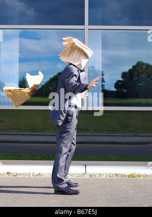 Businessman with newspaper over face Stock Photo