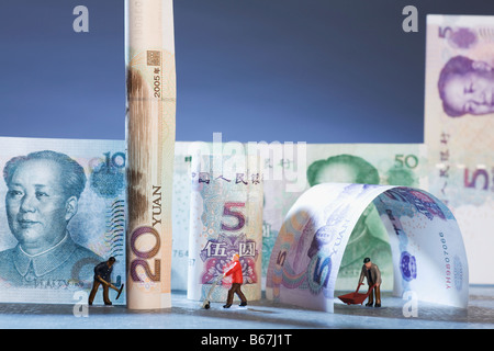 Figurines of manual workers with Chinese currency Stock Photo