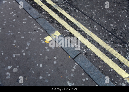 Chewing gum stuck to the pavement and road surface, and a double yellow line and pavement tick. (44) Stock Photo