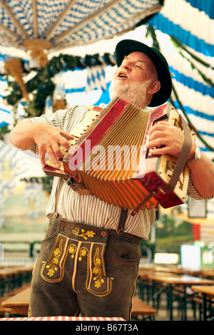 Man wearing bavarian costume playing melodeon Stock Photo