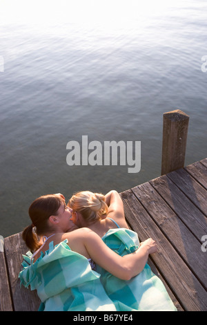 Two girls lying on jetty, Starnberger See, Bavaria, Germany Stock Photo