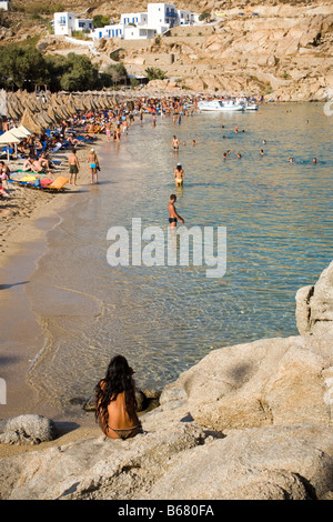 View from a woman sitting on a rock to bathing people at Super Paradise Beach, knowing as a centrum of gays and nudism, Psarou, Stock Photo
