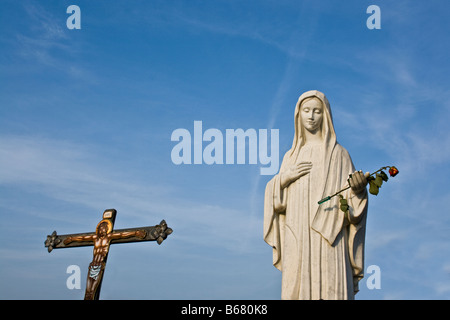 Blessed Virgin Mary statue and a cross in the sanctuary Medjugorje, Bosnia Herzegovina Stock Photo