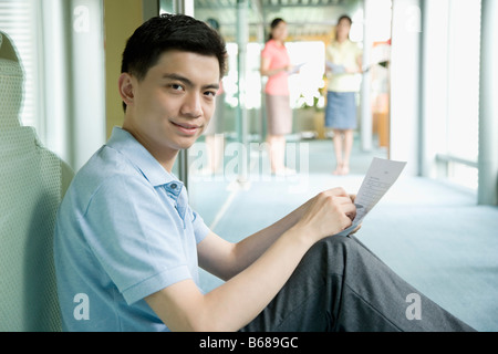 Portrait of a male office worker holding a form