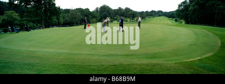 Golfing in Glasgow at Pollock golf club, Scotland, on the green at the hole. Stock Photo