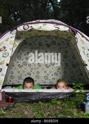 Couple looking out of tent Stock Photo