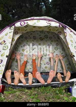 Four friends stretching in tent Stock Photo