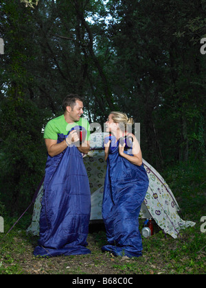 Couple jumping in sleeping bags Stock Photo