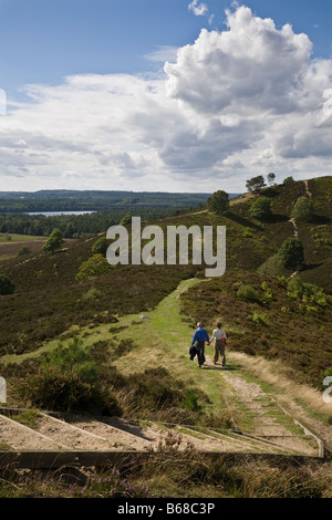 Couple walking on Stovbjerg hill and view to Sindbjerg hill and lake Brassø, near Sejs, Jutland, Denmark Stock Photo