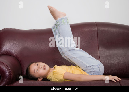 Side profile of a girl playing on a couch Stock Photo