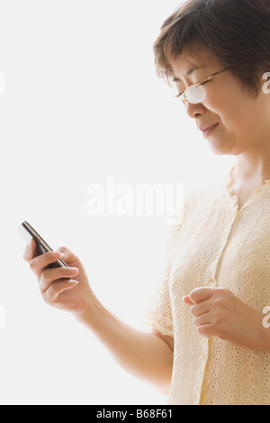 Close-up of a mature woman text messaging Stock Photo