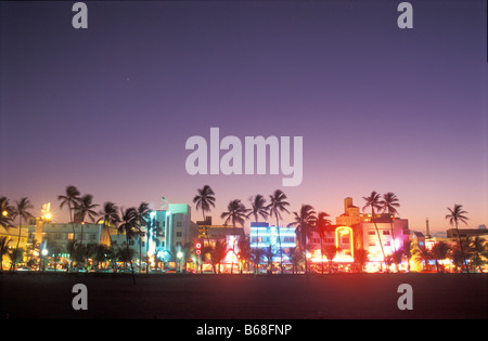 Glowing neon accents art deco era hotels along Ocean Drive at twilight Miami Beach Florida Stock Photo
