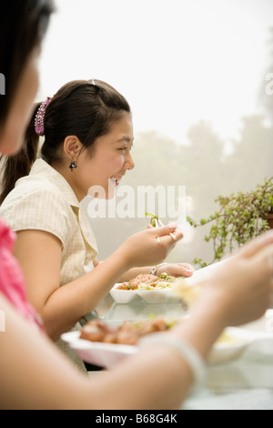 Side profile of two female office workers having lunch and smiling Stock Photo