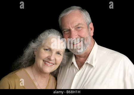 A good looking silver haired mature couple over a black background Stock Photo