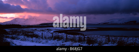 Dark and stormy winter sunset over the snowy Cuillin Hills, from Breakish, Island of Skye, Hebrides, Scotland, UK. Stock Photo