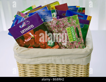 Several flower seed packets in a basket ready to be opened and sown Stock Photo