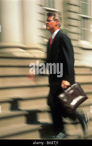Businessman striding up building stairs, 1996 Stock Photo