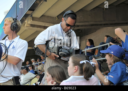 Video camera crew transmitting images of excited young baseball fans Stock Photo