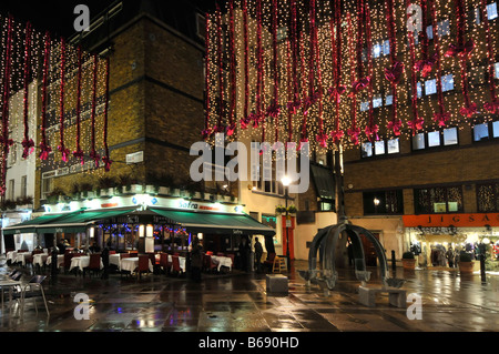 Christmas decorations St Christophers Place shopping & eating out area off 'Oxford Street' in Londons West End rainy evening Stock Photo