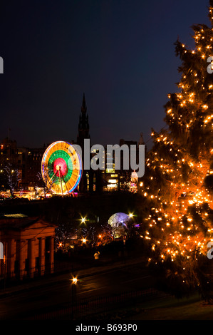 Edinburgh Christmas tree on the Mound with the illuminated National Galleries and Winter wonderland in background, Scotland Stock Photo