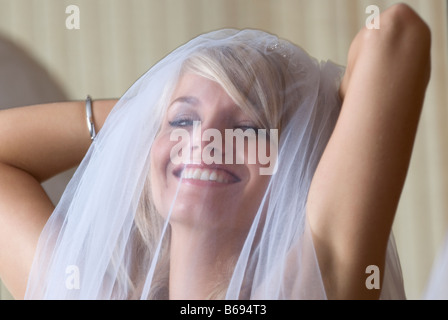 Bride wearing veil laughing Stock Photo