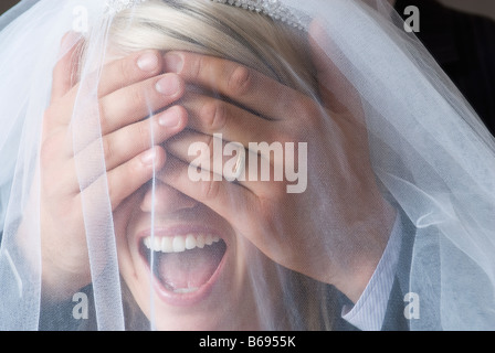 Groom covering brides eyes, close-up Stock Photo