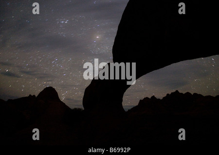 Africa Namibia Usakos Star trails above granite arch near Spitzkoppe mountain at night in Namib Desert Stock Photo