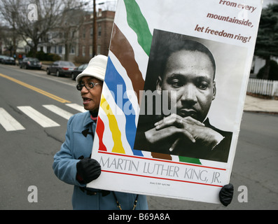 A woman holds a Dr. Martin Luther King poster during a parade during Martin Luther King Holiday in the USA. New Haven, CT. Stock Photo