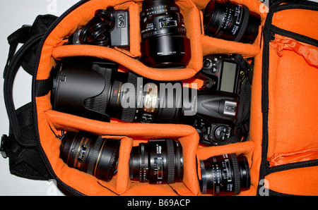 A camera bag, perfectly organized, filled with Nikon photography equipment, telephoto lenses, flash, cables, camera body. Stock Photo
